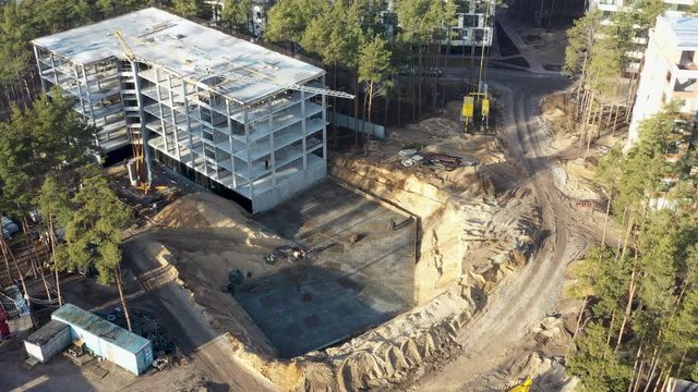 Construction activity in the forest, change of landscape due to infrastructure development work. Destruction of fauna and flora by builders. Flying drone over construction site.