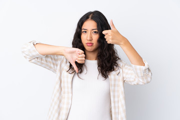 Naklejka premium Mixed race woman over isolated white background making good-bad sign. Undecided between yes or not