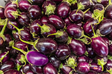 Full frame close up of a bunch of purple aubergines. For wallpaper or background use. Organic vegetables at the local food market.