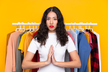 Mixed race woman in a clothing store pleading