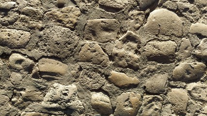 A bridge street made of small rounded stones in the center of the old city. The gray cobblestones...