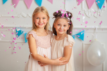 Obraz na płótnie Canvas Happy birthday Happy cute children in festive decor and beautiful dresses play with confetti.