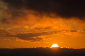 Dramatic sunset, cloudy sky of an intense orange color, in San Clemente del Tuyu