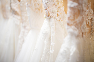 Wedding dress close up at the wedding salon. Wedding dresses hanging on a hanger. Fashion look....