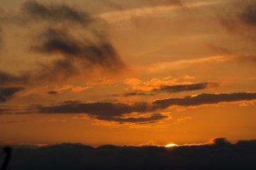 Fototapeta na wymiar Dramatic sunset, cloudy sky of an intense orange color, in San Clemente del Tuyu