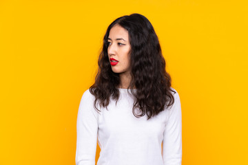 Fototapeta premium Mixed race woman over isolated yellow background looking side