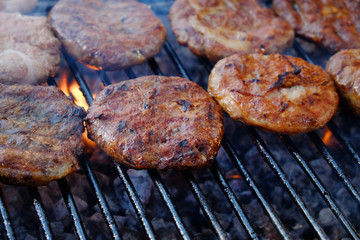 Cooking hamburgers on grill on flame. Food meat preparing. Beef burgers on bbq barbecue.