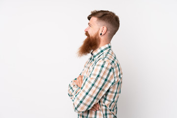 Redhead man with long beard over isolated white background looking side