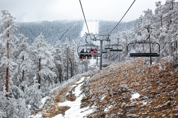 People in the cableway heading for a ski track