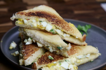 A stack of Bread and egg salad with mayonaise sandwich on a plate with copy space.