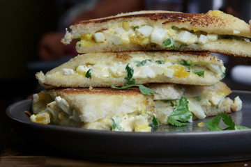 A stack of Bread and egg salad with mayonaise sandwich on a plate with copy space.