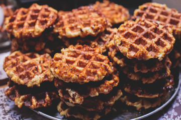 Fresh belgian stroopwafels waffles with caramel and chocolate, street food on traditional Christmas fair market