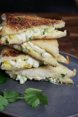 A stack of Bread and egg salad with mayonaise sandwich on a plate with copy space.