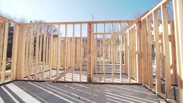 Timelapse of professional framers building wooden frame for future residential house. Sunny day