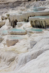 Fototapeta na wymiar The beautiful pools of Pamukkale in Turkey. Pamukkale contains hot springs and travertines, terraces of carbonate minerals left by the flowing water. The site is a UNESCO World Heritage Site.