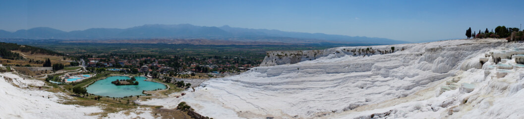 Fototapeta na wymiar The beautiful pools of Pamukkale in Turkey. Pamukkale contains hot springs and travertines, terraces of carbonate minerals left by the flowing water. The site is a UNESCO World, panoramic view