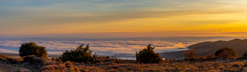 panoramic view of sunrise over the clouds on the mountain.
