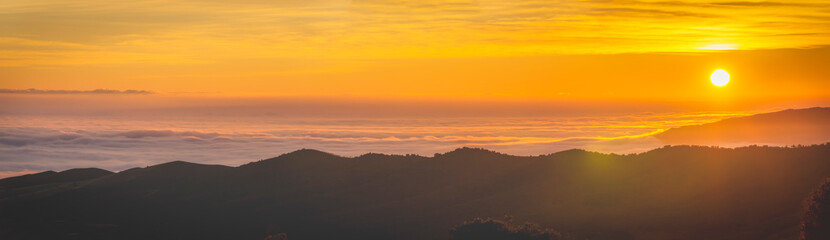 panoramic view of sunrise over the clouds on the mountain.