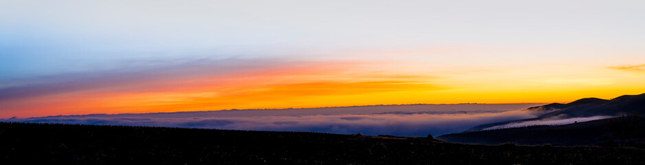 panoramic view of sunrise over the clouds on the mountain.