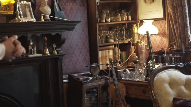 Close-up of the room in Sherlock Holmes Museum with fireplace, violin and chemical reagents. Action. It is a privately run museum in London, dedicated to the famous detective.