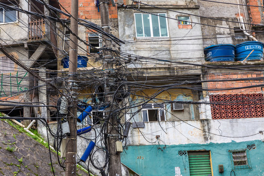 Messy electrical utility cables on an urban street with buildings in the background on a street in Rocinha favela, a shanty town or slum in Rio, Brazil