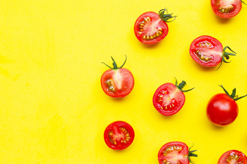 Fresh tomatoes, whole and half cut isolated on yellow background.