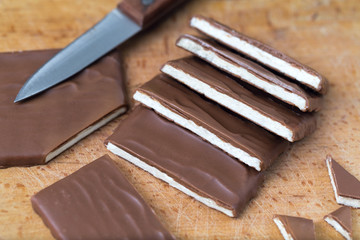 cutting chocolate into small pieces, chocolate with coconut filling, handmade chocolate bars