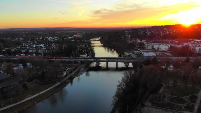 Drone flight towards bridge while a red train is crossing the bridge