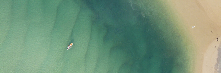 Aerial view of beautiful turquoise sea ocean, a man on paddleboard and sandy beach,  recreation lifestyle and  reopen tourism, social distance concept, Top view from drone, World Oceans Day