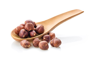 hazelnuts in wood spoon on white background