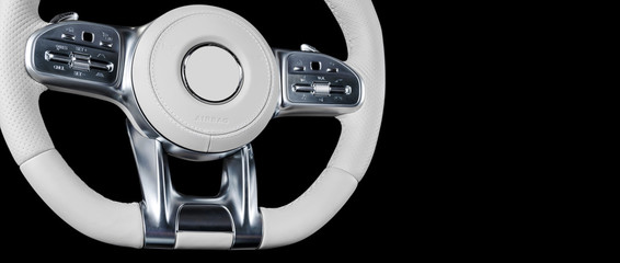 Modern car interior. Steering wheel with media phone control buttons isolated on black background....