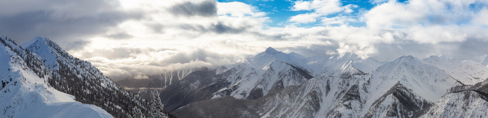Kicking Horse, Golden, British Columbia, Canada. Beautiful Aerial Panoramic View of Canadian Mountain Landscape during a vibrant sunny and cloudy morning sunrise in winter.