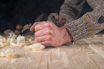 Joinery. Planing a natural wood furniture panel with a manual planer