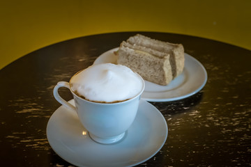 Cup of hot cappuccino coffee with sandwiches for breakfast in the morning.