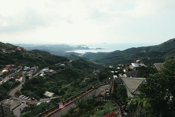 Old style photo of vintage asian style village name "Juifen" slope on hill with sea and cloudy sky background landscape