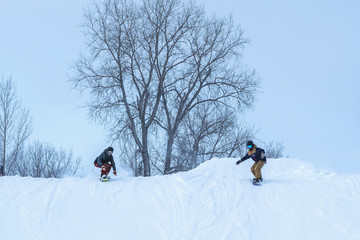 People are having fun in downhill skiing and snowboarding in the middle of snowfall 