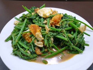 Thai food style, Top view of stir fried chayote in white plate on wooden table in restaurant, Healthy food concept, Ready to eat or serve