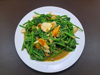 Thai food style, Top view of stir fried chayote in white plate on wooden table in restaurant, Healthy food concept, Ready to eat or serve