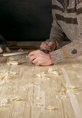 Joinery. Planing a natural wood furniture panel with a manual planer