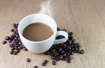 cup of coffee and beans on wooden table
