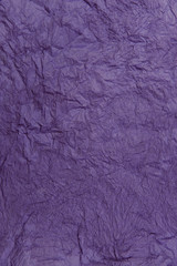 Abstract textured background. Violet background. Texture of crumpled purple paper. Beautiful purple surface. Vertical, close-up, free space for text. Design concept.