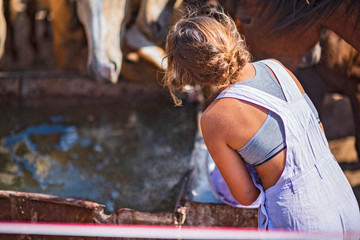 Obraz na płótnie Canvas A girl on a farm with horses. Photographed close-up.