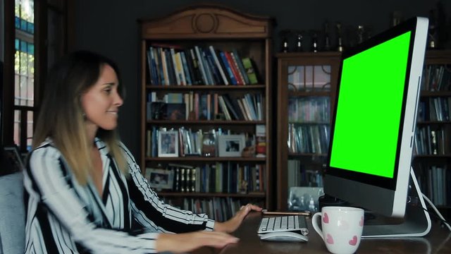 Business Woman Working at the Office with a Computer Green Screen and Receiving Good News. 