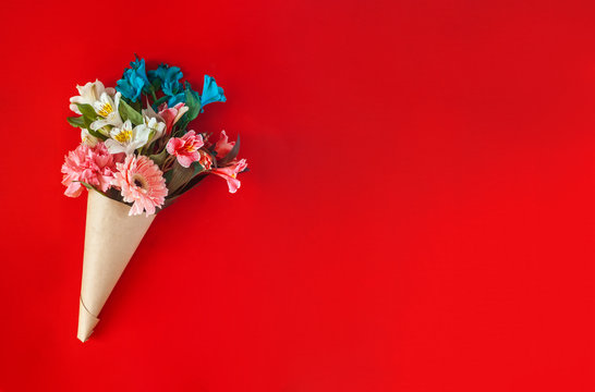 A bouquet of fresh spring flowers on the red background. Top view of spring floral background with copy space