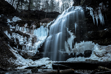 View of Tiffany waterfall in the forest in winter with snow and icicles 
