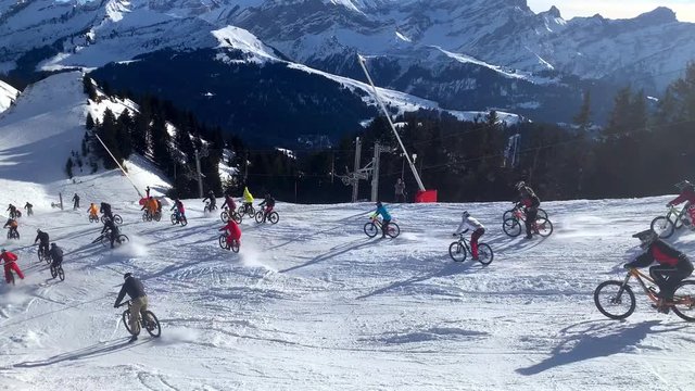 Large disorganized bike crash on snow in the mountains. Snow biking accident
