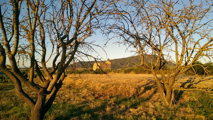 Beautiful spanish countryside landscape, orange tones. Old church in the background. on the way of St James, Camino de santiago.
