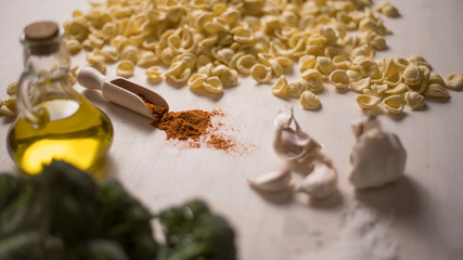 Close-up of typical Italian Apulian fresh pasta orecchiette on a table with broccoli, garlic, oil and chilli powder 