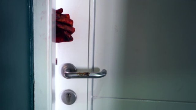 Scary woman hand coming out the open house door
