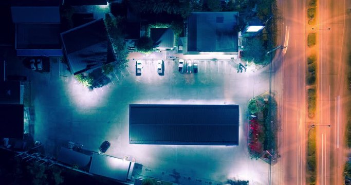 Gas station, petrol station or service station at night. And convenience store, shop, grocery, market or minimart. Light movement from car on road. For refueling, shopping. Aerial view hyperlapse.